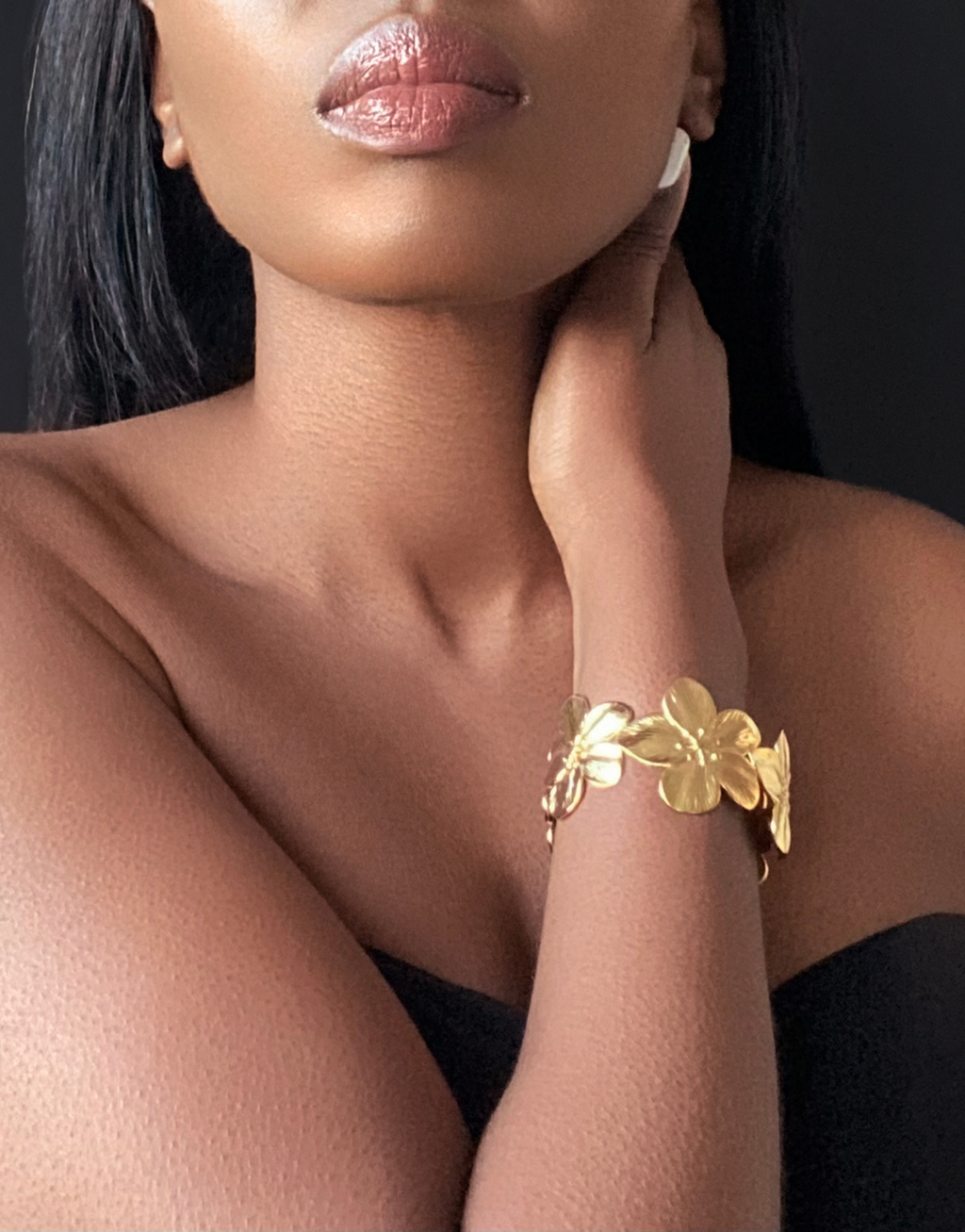 Close-up of a model wearing the ABYDOS Flower Cuff Bracelet, featuring a bold floral design in 18k gold-plated stainless steel, elegantly styled for a sophisticated look.