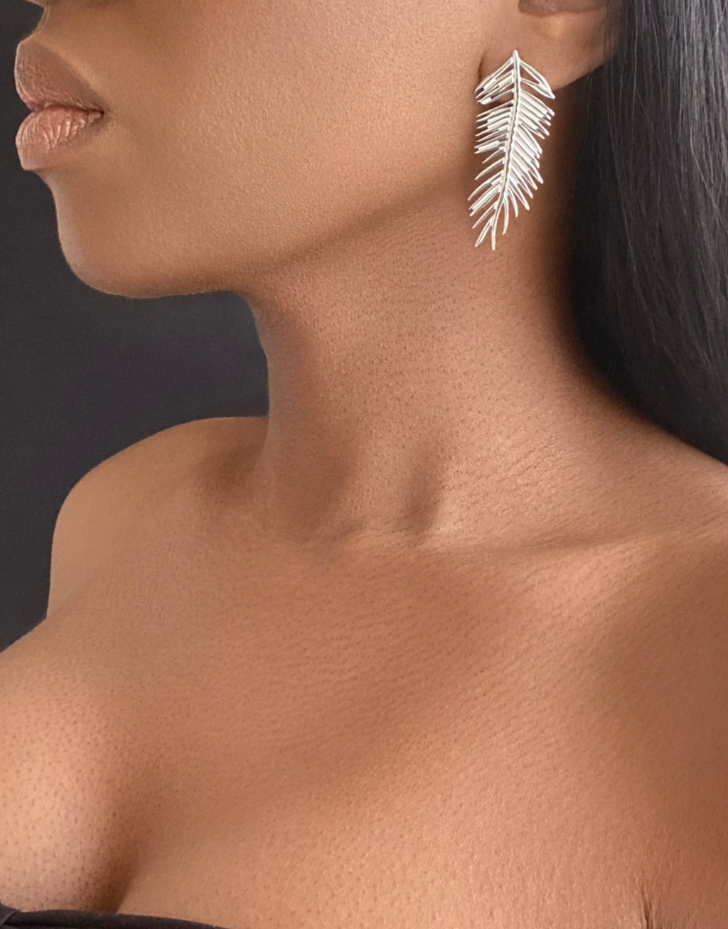 Close-up of a model wearing the ACICULAR Long Leaves Stud Earrings in silver, featuring a unique and elegant design inspired by nature. Perfect for everyday wear or special occasions, crafted with high-quality materials for a timeless look.